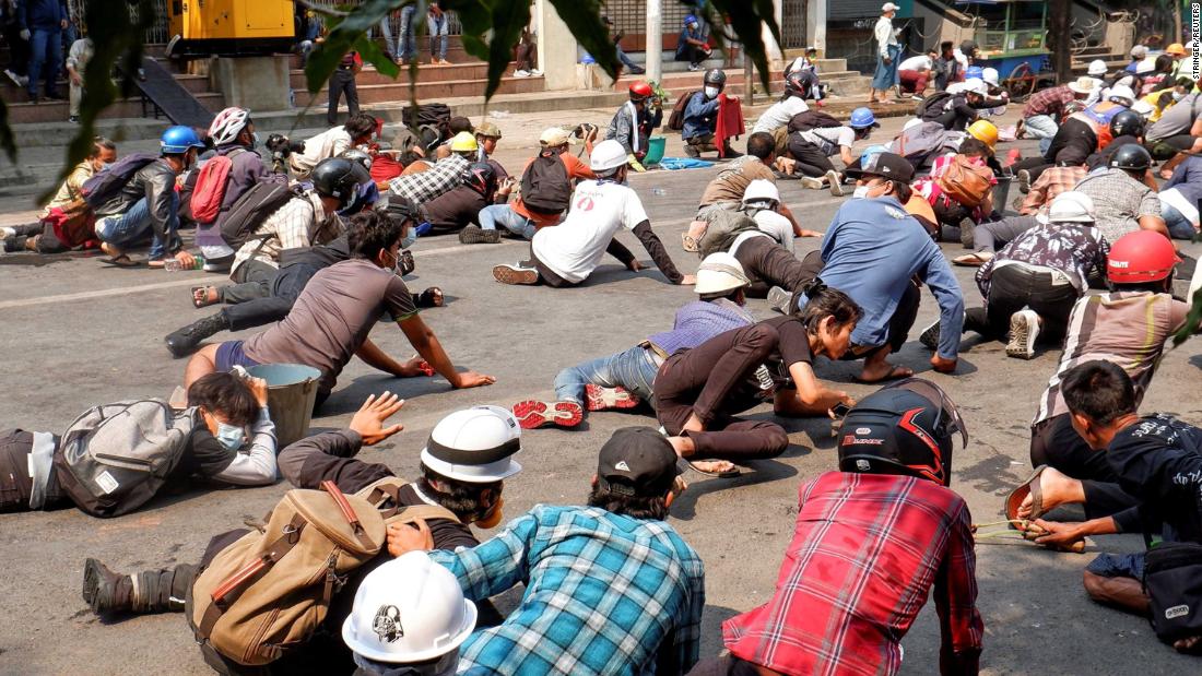 Protesters lie on the ground after police opened fire to disperse an anti-coup demonstration in Mandalay on March 3.
