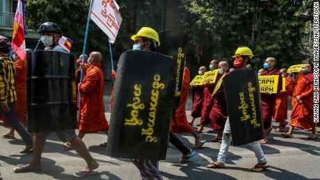 Demonstranten tragen Plakate und provisorische Schilde während eines Protestes gegen den Militärputsch in Mandalay, Myanmar, am 7. März.