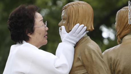 In this 2019 照片, Lee Yong-soo, who was forced to serve for the Japanese troops as a &quot;comfort woman,&quot; holds the face of a statue symbolizing the issue of wartime &quot;comfort women&报价; during its unveiling in Seoul, 南韩.