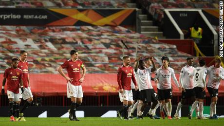 Manchester United players react as AC Milan players celebrate.