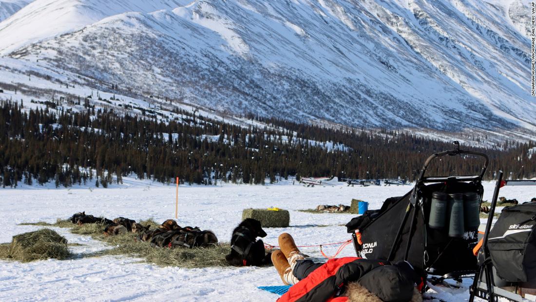 Pete Kaiser naps under his coat during a stop at the Rainy Pass checkpoint.