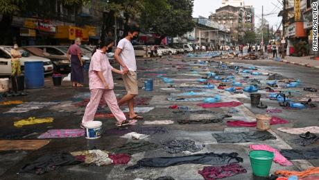 People walk in a street full of water bags to be used against tear gas, during an anti-coup protest at Hledan junction in Yangon, Myanmar, on March 14.