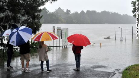 Residents look at the swollen Nepean river during heavy rain in western Sydney on March 20.