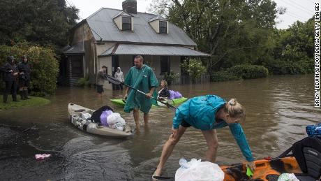 Residents unload household items from kayaks at a street submerged in floodwaters in Windsor, New South Wales, Australia, on March 22.