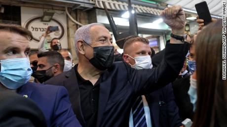 Netanyahu cheers to supporters as he tours a market in Jerusalem on Monday.