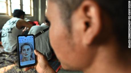 A Myanmarese policeman, who fled Myanmar and crossed illegally to India, looks at a picture of detained Myanmar civilian leader Aung San Suu Kyi on his social media at an undisclosed location in India&#39;s northeastern state of Mizoram on March 13, 2021. - Scores of Myanmar policemen and their families have now fled to India, security officials said on March 12, with one officer telling AFP that the authorities are &quot;beating and torturing&quot; protestors. (Photo by Sajjad HUSSAIN / AFP) (Photo by SAJJAD HUSSAIN/AFP via Getty Images)