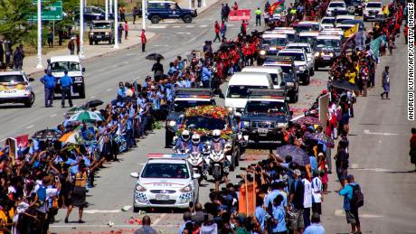 People line up as police escort a hearse carring the coffin of Papua New Guinea&#39;s first Prime Minister Michael Somare in Port Moresby on March 11.