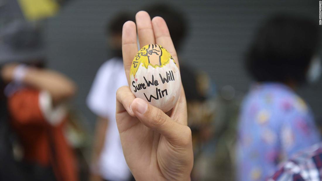 An anti-coup protester raises a decorated Easter egg along with the three-fingered salute of resistance during a demonstration in Yangon on April 4.