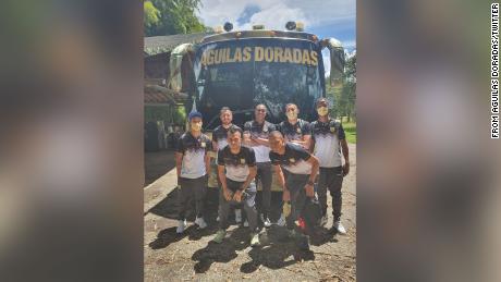 Águilas Doradas&#39; depleted team pose for a photo next to the team bus.