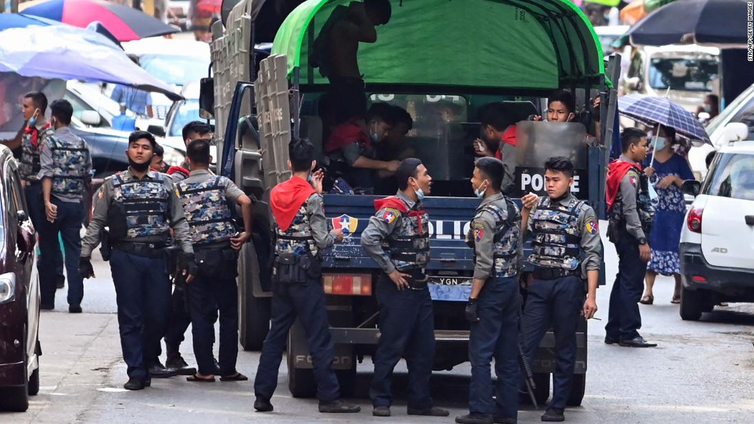 Police talk as they arrive at the site of a demonstration in Yangon on April 12.