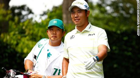 Matsuyama talks with his caddie Shota Hayafuji on the second tee during the final round of the Masters.