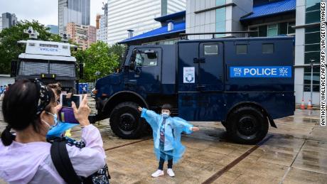 A young visitor poses in front of a police vehicle at the city&#39;s police college during an open day to celebrate the National Security Education Day in Hong Kong on April 15, 2021.