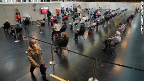 Patients sit in a monitoring area after receiving a Covid-19 shot at the Arena Berlin mass vaccination center on April 15, 2021 in Berlin, Germania.