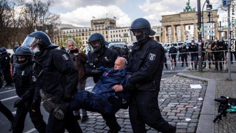 Police carry a demonstrator during protests against new legislative measures to rein in the coronavirus pandemic next to the Brandenburg Gate,  in Berlin, in aprile 21.