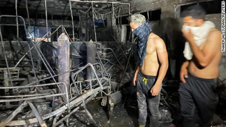 People look on at Ibn al-Khatib hospital after a fire ignited in Baghdad on April 25.