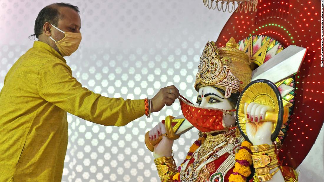 A Hindu priest puts a face mask on an idol of the Goddess Ashapura during Navaratri celebrations in Beawar on April 13.