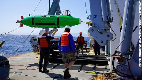 Scripps researchers aboard the Research Vessel Sally Ride recover the REMUS 6000 autonomous underwater vehicle to survey the seafloor. 