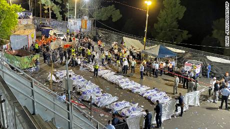 Los oficiales de seguridad y los rescatistas israelíes rodean los cuerpos de las víctimas que murieron durante la noche en el monte Meron.