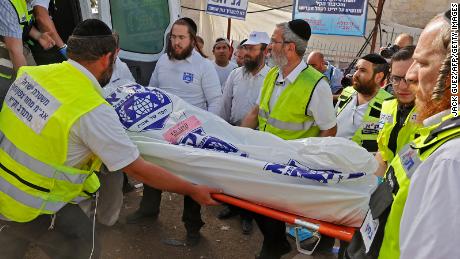 Los equipos de rescate israelíes llevan un cuerpo a una ambulancia en el monte Meron el viernes. 