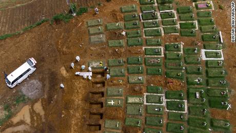 Workers bury a coffin containing the body of a Covid-19 victim at a cemetery reserved for coronavirus deaths in North Sumatra, Indonesia.