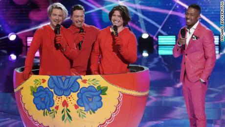 THE MASKED SINGER: Isaac, Taylor and Zac Hanson with host Nice Cannon in &quot;The Quarter Finals - Five Fan Favorites!&quot; episode of THE MASKED SINGER airing Wednesday, May 12 (8:00-9:00 PM ET/PT), © 2021 FOX MEDIA LLC. CR: Michael Becker/FOX.