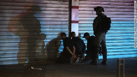 An Israeli security soldier detains three Arabs during clashes between Jews, Arabs and police in Lod on May 13.
