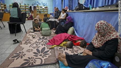 Palestinian families take shelter in a UN school in Gaza City on May 13, 2021, after fleeing from their homes in the town of Beit Lahia. 
