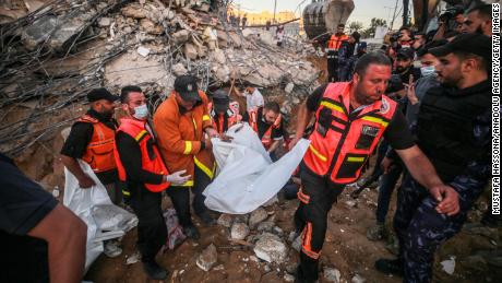 Palestinian civil defense teams take part in recovery efforts amid the rubble of a building after Israeli fighter jets conducted airstrikes in Beit Lahia, Gaza on May 13.