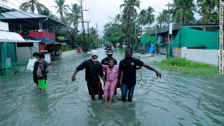 Police and rescue personnel evacuate a local resident through a flooded street in a coastal area in Kochi on May 14.