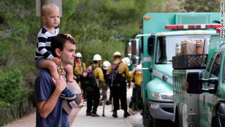 Pacific Palisades resident Mike Sutton, 31, and his son, Tommy, 2, watch the deployment of firefighters Sunday.