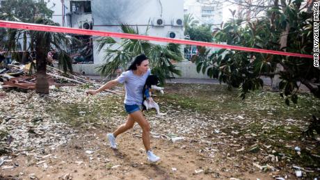 A woman runs for a shelter in Ashdod, Israel, after sirens warned of rockets fired from Gaza on Monday.