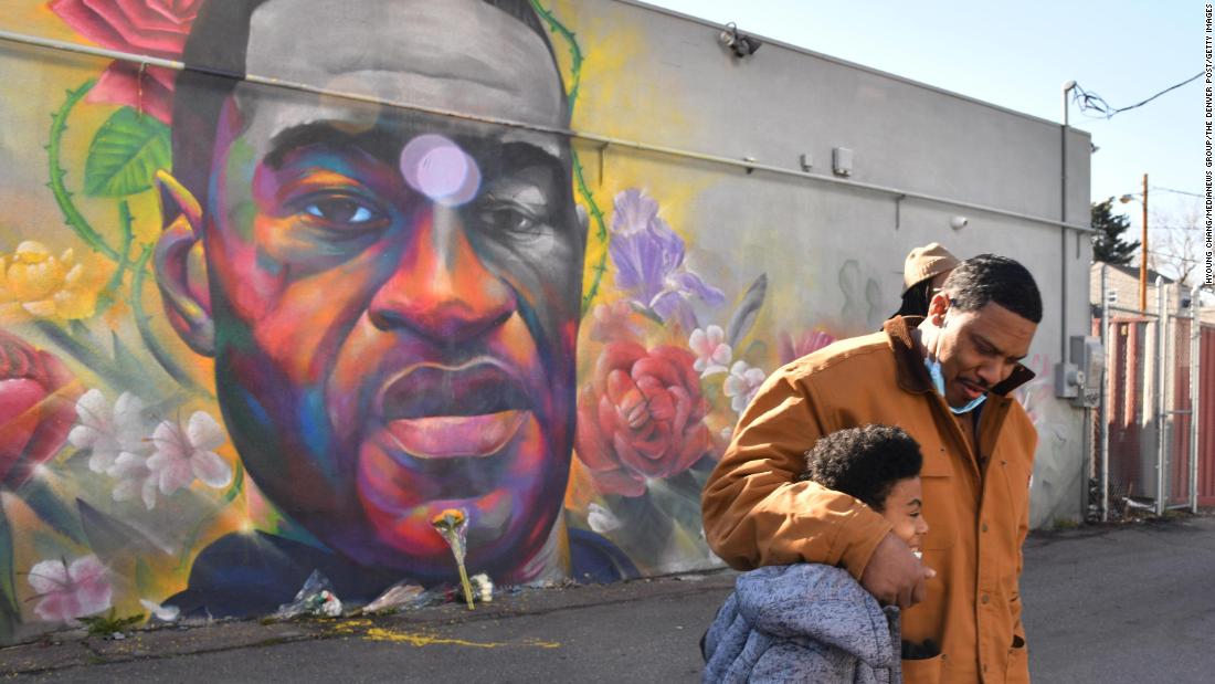 James Stapleton embraces his 11-year-old son, Kareem, after they prayed for Floyd at a mural in Denver on April 20.