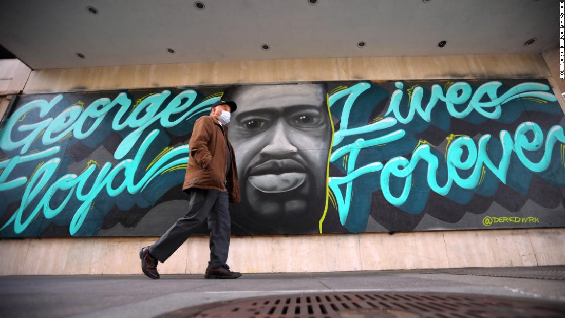 A man walks past a Floyd mural on an office building in Oakland, カリフォルニア, 行進に 29.