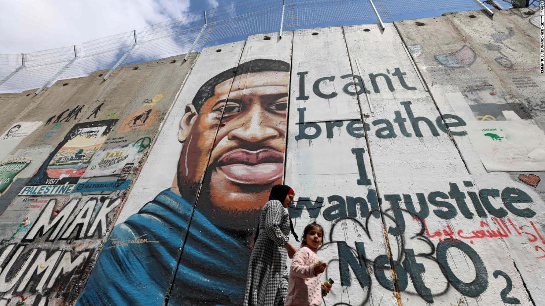 People walk past a Floyd mural in Bethlehem, West Bank, 行進に 31.