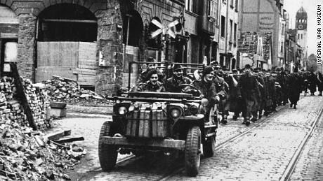 X trooper Ian Harris leading captured German prisoners in April 1945.
