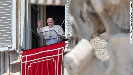 Pope Francis waves from a window overlooking St. Peter&#39;s Square in the Vatican during the weekly Angelus prayer followed by the recitation of the Regina Coeli on May 9, 2021.