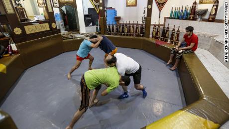 Iranians wrestle during a workout session at the traditional Shir Afkan &quot;zurkhaneh&quot; (House of Strength) gymnasium in the capital Tehran in February 2018.