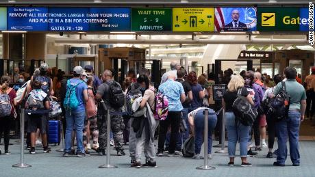 Travelers line up to go through a TSA checkpoint at Orlando International Airport before the Memorial Day weekend on Friday, Mayo 28, 2021, in Florida.