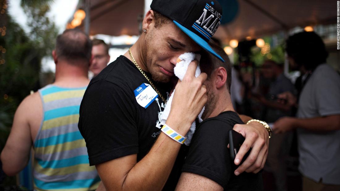 A pair embrace after exiting Parliament House, a gay bar and resort where people were gathering on June 12, 2016, in the wake of the mass shooting at the Pulse nightclub in Orlando, 플로리다.