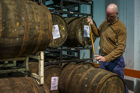 Town Branch Distillery&#39;s blender and distiller Alan Kennedy uses a whiskey thief to extract bourbon from a freshly tapped barrel.