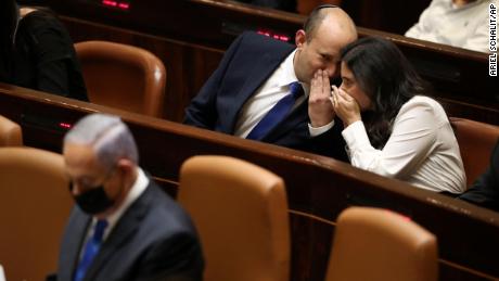 Israel&#39;s new Prime Minister Naftali Bennett and his coalition partner Ayeet Shaked speak behind Benjamin Netanyahu during the Knesset session.