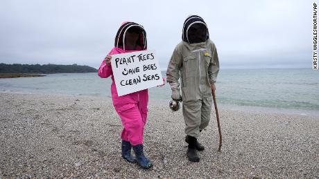 Climate activists Delores and Leroy Tycklemore wear bee keeping suits in a protest in Falmouth, 英国, 在周五, 六月 11.