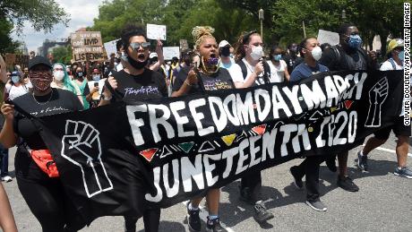 Demonstrators chant as they take part in a Juneteenth march and rally in Downtown Washington, DC, on June 19, 2020.