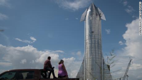 Space enthusiasts look at a prototype of SpaceX&#39;s Starship spacecraft at the company&#39;s Texas launch facility on September 28, 2019 in Boca Chica near Brownsville, Texas. The Starship spacecraft is a massive vehicle meant to take people to the Moon, Mars, and beyond. (Photo by Loren Elliott/Getty Images)