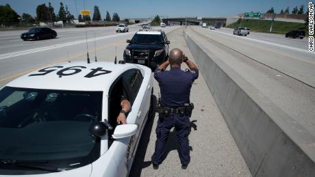 California Highway Patrol officer Matthew Musselmann uses a laser gun to detect speeders on Interstate 5 on April 23, 2020, in Anaheim.