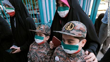 A mother and her children, wearing Islamic Revolutionary Guard Corps&#39; uniforms, line up at a polling station on Friday.