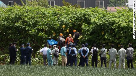 Police officers and members of a hunting group search for a brown bear on the loose in Sapporo, 日本, 6月に 18.