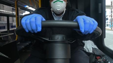 A bus driver for the Detroit city bus line DDOT poses for a portrait wearing a protective mask and gloves for protection in Detroit on March 24, 2020, during the novel coronavirus outbreak.