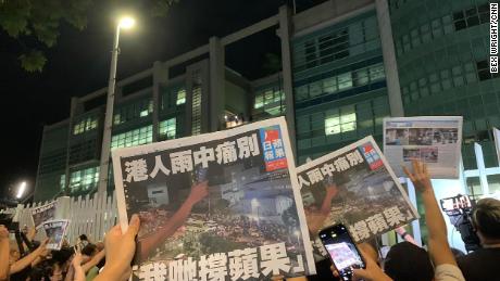 Apple Daily supporters wave free copies of the final edition.