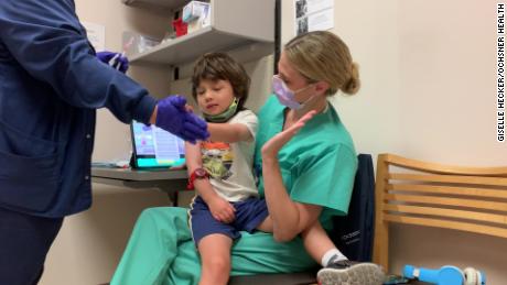 Christian Bui, 3, gives high fives after getting his first shot of either a Pfizer vaccine or a placebo.